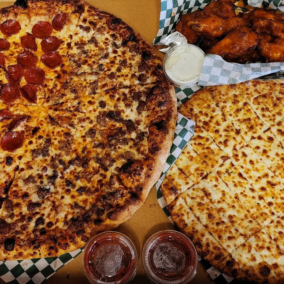 Caprigios Pizza: a large pepperoni and sausage pizza, garlic knots, and chicken wings with dipping sauces.