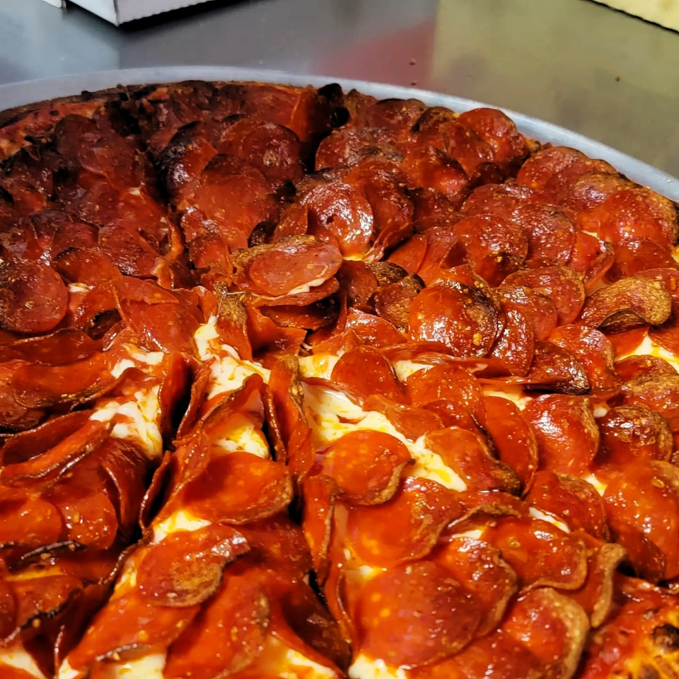Close-up of a Caprigios Pizza pepperoni pizza, with half of the pepperoni slightly burnt.